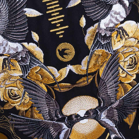 The Custom Song Code Unisex Embroidered Hoodie features black and gold birds, yellow roses, and circular patterns with intricate stitching and a central bird silhouette.