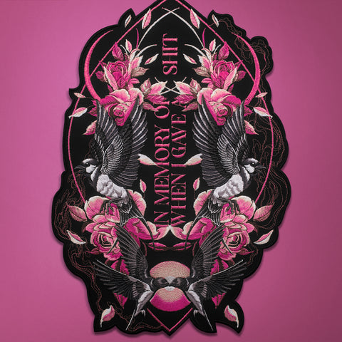 The Swallows And Flowers Custom Embroidered Patch features pink roses, black and white birds, and the quote "In memory of a shit I gave" on a pink background—a unique, symmetrical design blending floral and bird motifs.