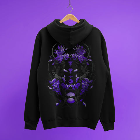 A Custom Song Code Unisex Embroidered Hoodie in black hangs against a purple background. The back features an intricate embroidered design with purple flowers, hands, leaves, crescent moons, and symmetrical patterns.