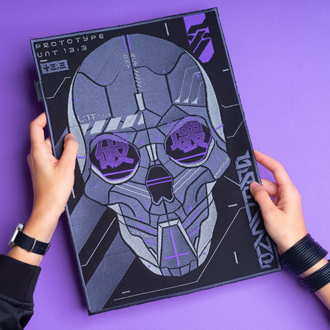 A person holds a futuristic Cyberpunk Skull Embroidered Patch, showcasing a robotic skull with circuit-like details and Japanese characters in the eyes, all on a vibrant purple background.