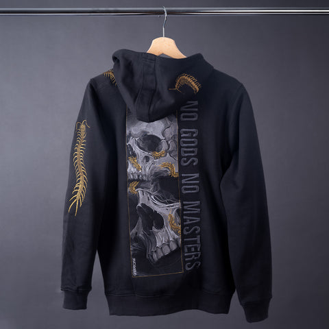 The Skull & Scolopendras Limited Edition Embroidered Hoodie hangs on a wooden hanger, showcasing overlapping skulls, a large centipede, and “NO GODS NO MASTERS” on the back, plus a gold centipede detail on the sleeve for striking streetwear style.