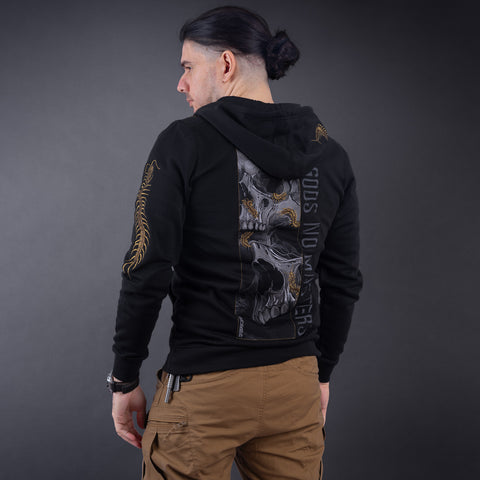 A man with dark hair in a ponytail wears the Skull & Scolopendras Limited Edition Embroidered Hoodie, featuring a large skull and GODS NO MASTERS text on the back, paired with tan cargo pants—bold streetwear against a dark background.