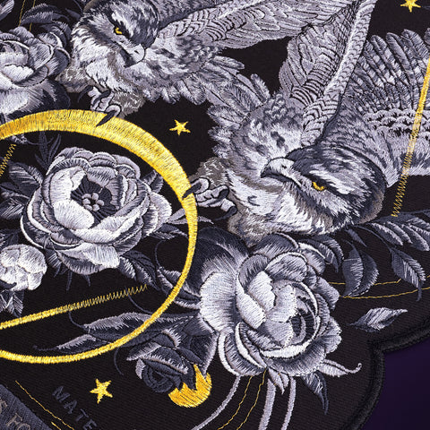 The Eagles Embroidered Custom Patch features two eagles, roses, and leaves in gray and white on black fabric. A yellow crescent and stars add celestial accents to this customizable patch design.